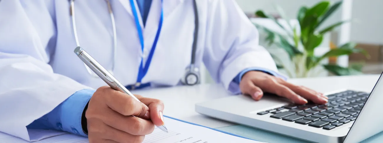 lekarz piszacy na laptopie